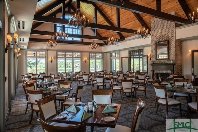 dining room with high vaulted ceiling, a brick fireplace, wooden ceiling, and a chandelier