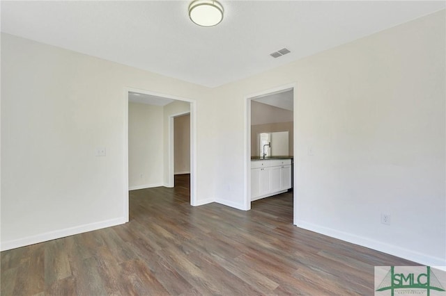 unfurnished room with sink and dark wood-type flooring