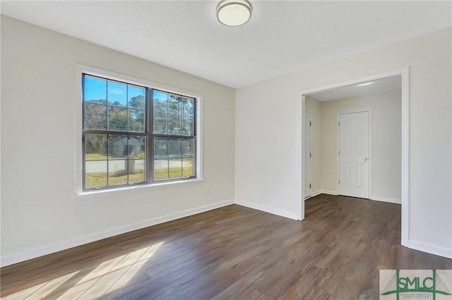 unfurnished room with dark hardwood / wood-style flooring