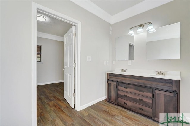 bathroom with wood-type flooring, vanity, a textured ceiling, and crown molding