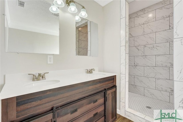 bathroom featuring vanity and tiled shower