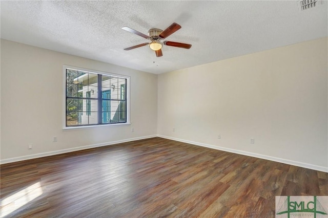 spare room with a textured ceiling, ceiling fan, and dark wood-type flooring