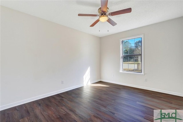 empty room with ceiling fan and dark hardwood / wood-style flooring