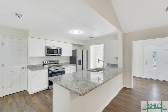 kitchen featuring white cabinets, appliances with stainless steel finishes, kitchen peninsula, and sink