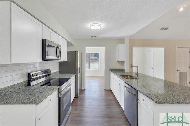 kitchen featuring white cabinetry, sink, stainless steel appliances, tasteful backsplash, and stone countertops