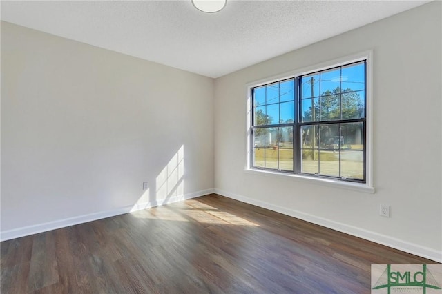 unfurnished room with dark hardwood / wood-style flooring