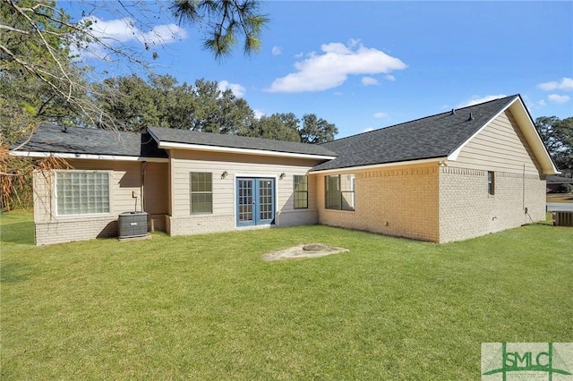 rear view of property with a yard and cooling unit