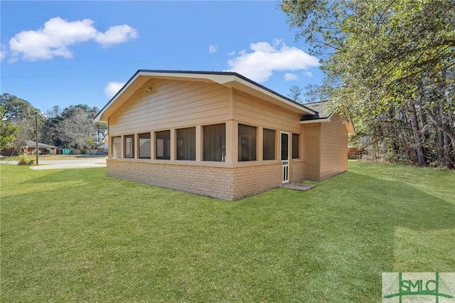 rear view of property with a sunroom and a yard