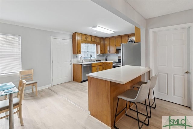 108 Dawson Ln, Ludowici, GA 31316 - kitchen with a breakfast bar, sink, appliances with stainless steel finishes, and light hardwood / wood-style flooring