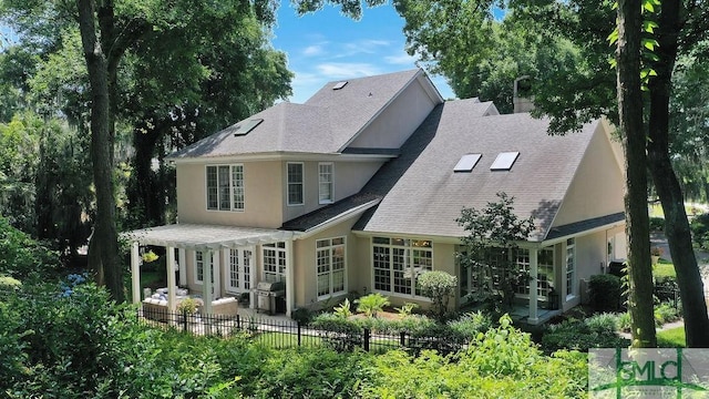 rear view of property featuring a pergola and a patio area