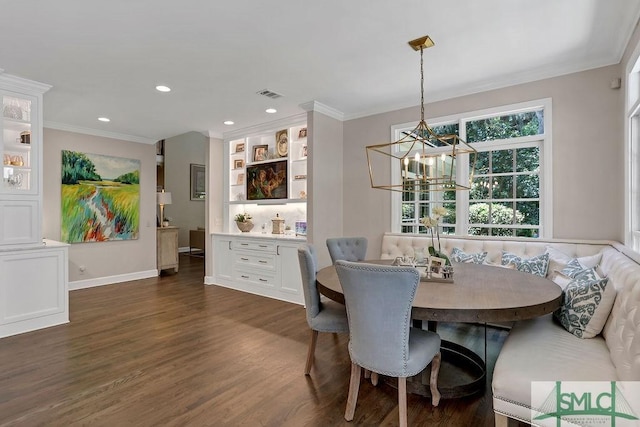 dining room with ornamental molding, breakfast area, dark wood-type flooring, and a notable chandelier