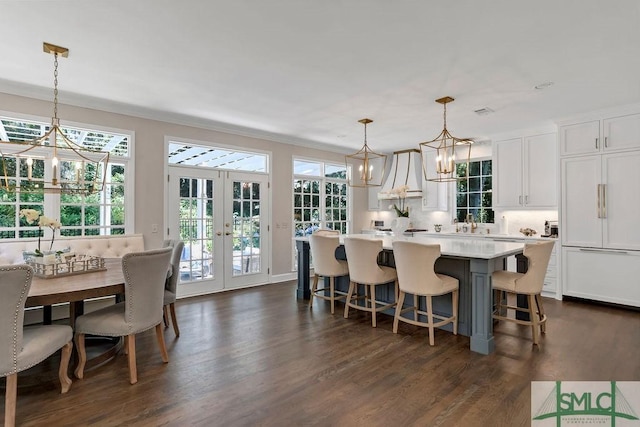 kitchen featuring french doors, paneled built in fridge, a center island, white cabinetry, and hanging light fixtures