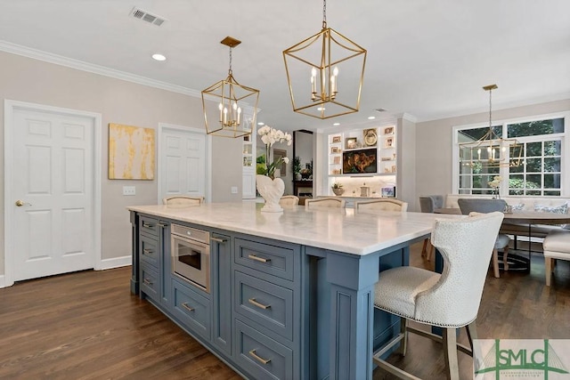 kitchen featuring pendant lighting, a kitchen island, ornamental molding, and dark wood-type flooring