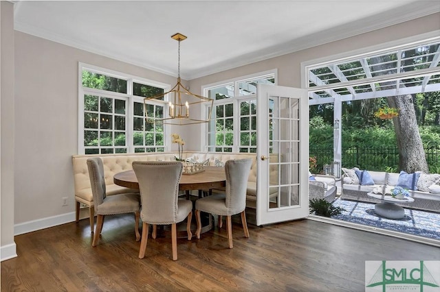 dining space featuring a notable chandelier, dark hardwood / wood-style floors, ornamental molding, and french doors