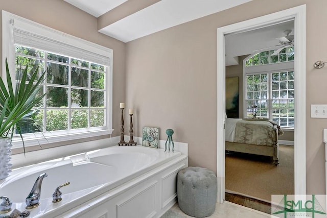 bathroom featuring tile patterned floors, a bathtub, and a healthy amount of sunlight