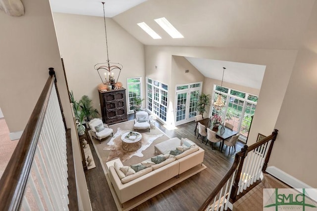 dining area with hardwood / wood-style flooring, high vaulted ceiling, and a chandelier