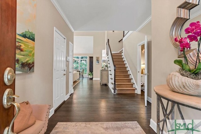 entryway with dark hardwood / wood-style floors and ornamental molding