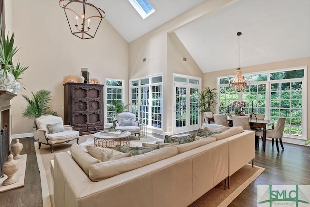 living room with a fireplace, dark wood-type flooring, high vaulted ceiling, and a notable chandelier