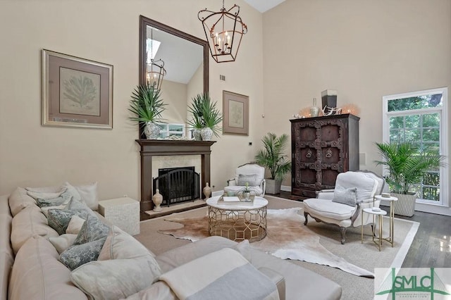 living room with hardwood / wood-style floors, high vaulted ceiling, and an inviting chandelier