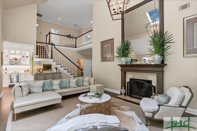 living room with a fireplace, a chandelier, and ornamental molding