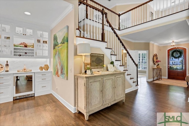 bar with white cabinets, crown molding, beverage cooler, and hardwood / wood-style floors