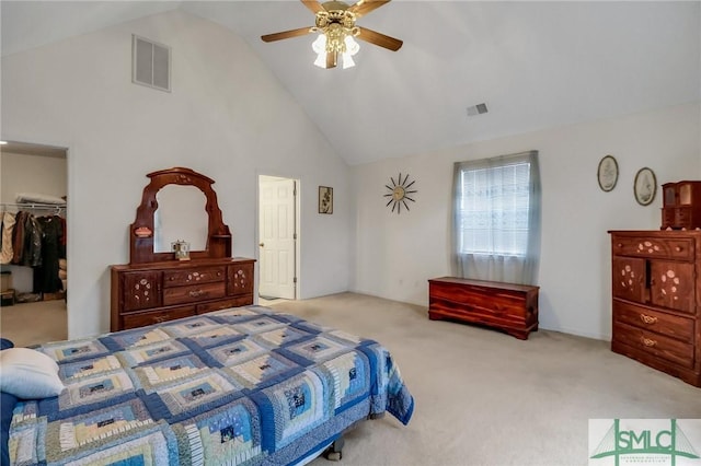 carpeted bedroom featuring ceiling fan, lofted ceiling, a walk in closet, and a closet