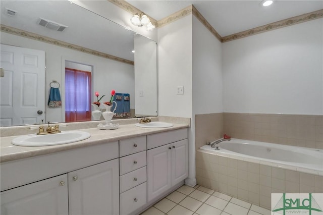 bathroom with tile patterned floors, tiled tub, and vanity