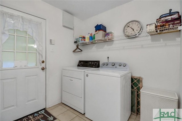 laundry area with washer and dryer and light tile patterned floors