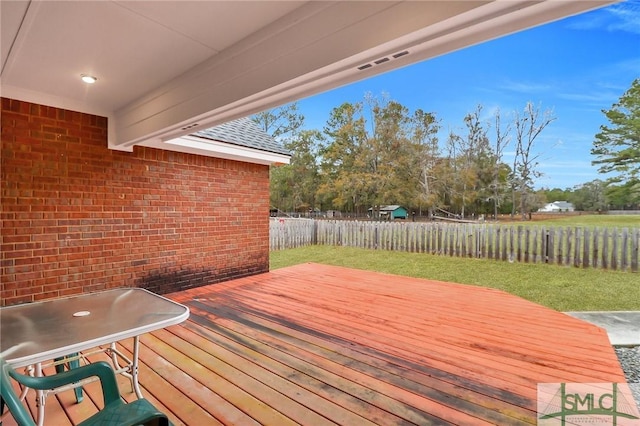 wooden terrace featuring a lawn