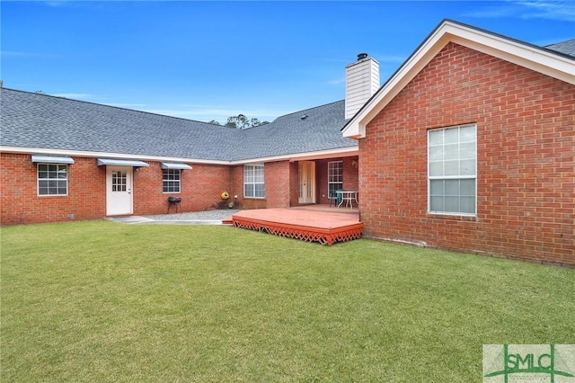 rear view of property with a yard and a deck