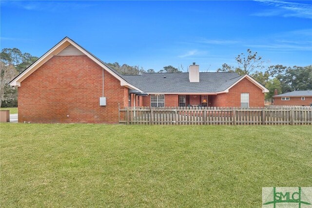 rear view of property featuring a yard