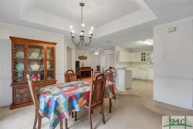 carpeted dining space with ceiling fan with notable chandelier, a raised ceiling, and crown molding