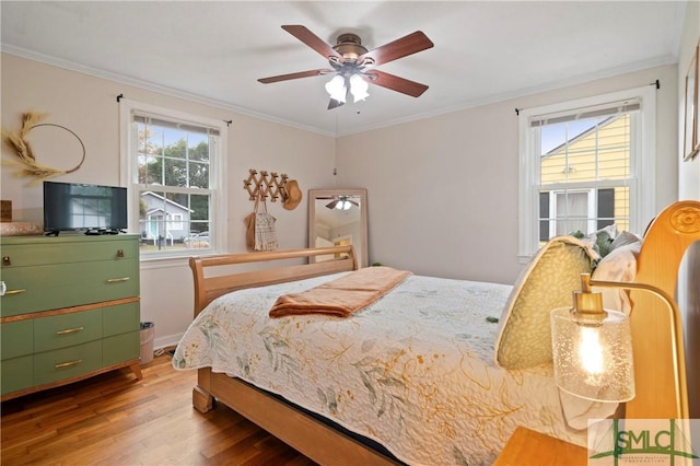 bedroom featuring ceiling fan, crown molding, and light hardwood / wood-style flooring