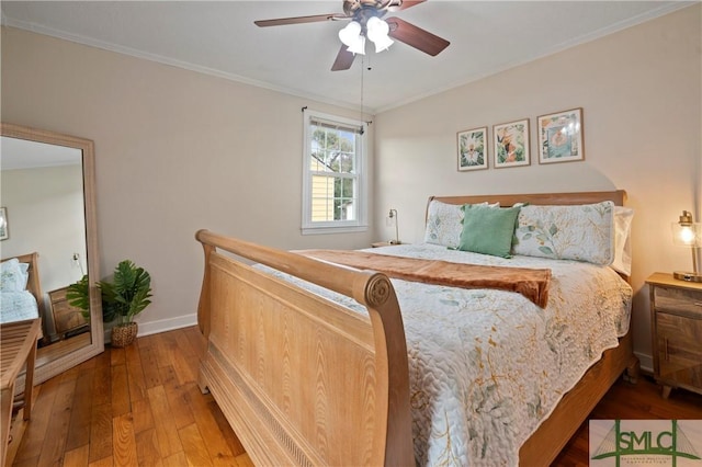 bedroom featuring hardwood / wood-style floors, ceiling fan, and ornamental molding