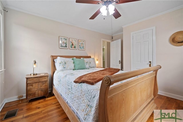 bedroom featuring hardwood / wood-style floors, ceiling fan, and ornamental molding