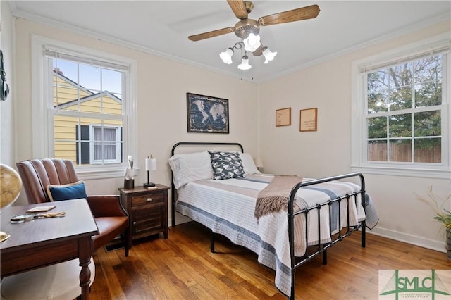 bedroom with ceiling fan, wood-type flooring, and ornamental molding