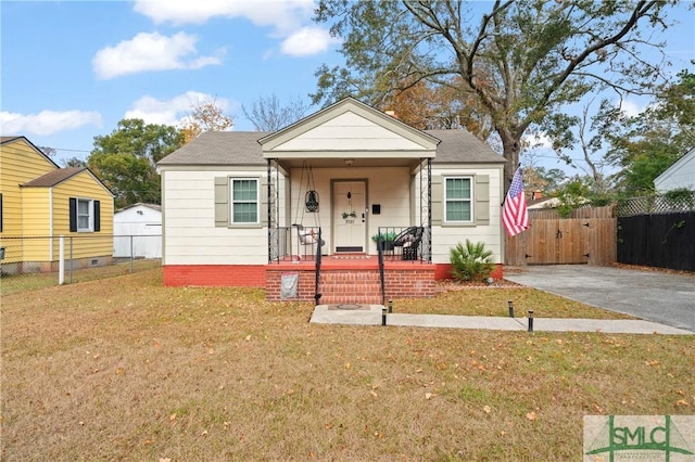 bungalow-style home featuring covered porch and a front lawn