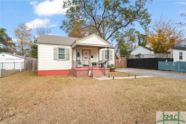 bungalow-style home featuring covered porch and a front lawn