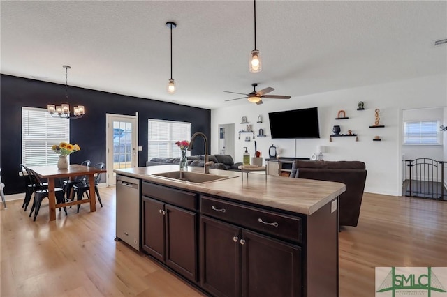 kitchen featuring sink, stainless steel dishwasher, an island with sink, decorative light fixtures, and dark brown cabinetry