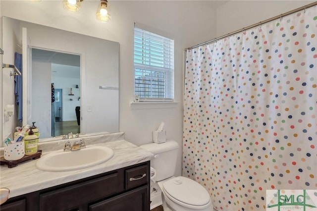 bathroom with a shower with shower curtain, vanity, and toilet