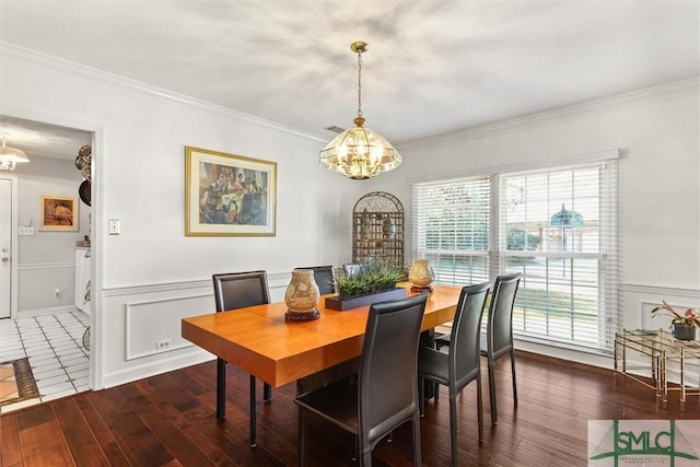 dining room featuring a notable chandelier, crown molding, and dark wood-type flooring