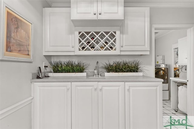 bar with washer / dryer, white cabinetry, crown molding, and sink