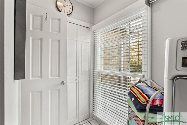 washroom featuring light tile patterned floors, crown molding, and washer / dryer