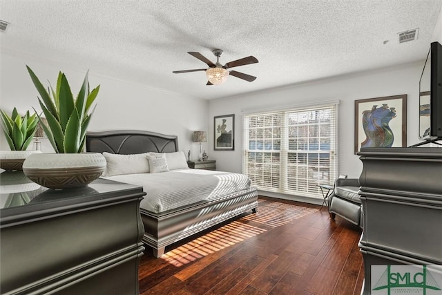 bedroom featuring a textured ceiling, dark hardwood / wood-style floors, and ceiling fan