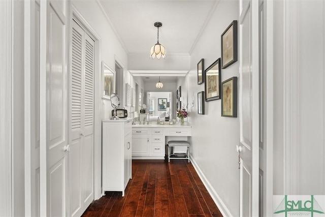 hall with dark hardwood / wood-style flooring and ornamental molding