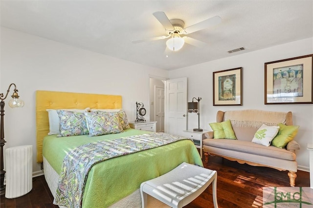 bedroom with ceiling fan, dark hardwood / wood-style flooring, and radiator