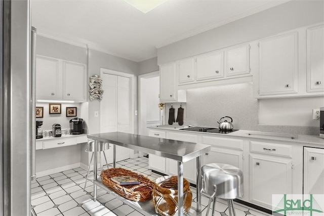 kitchen with white cabinets, black electric cooktop, and crown molding