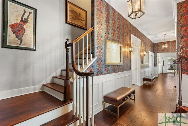 stairs featuring hardwood / wood-style floors and a notable chandelier