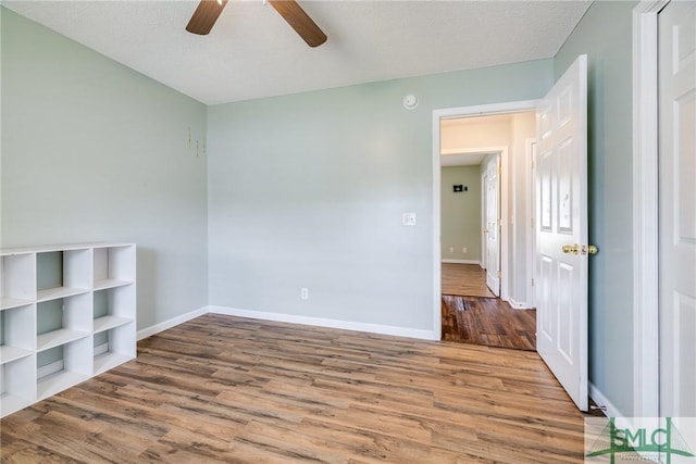 empty room featuring ceiling fan, hardwood / wood-style floors, and a textured ceiling