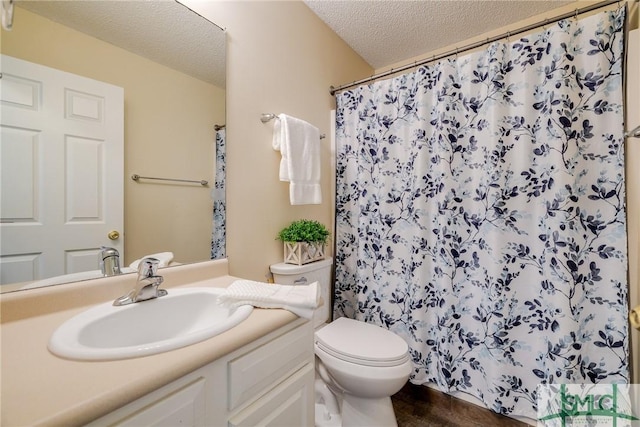 bathroom with curtained shower, vanity, a textured ceiling, and toilet